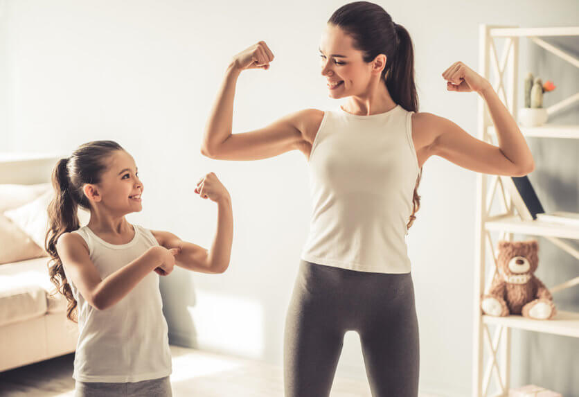 Mother and child flexing their muscles